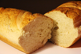 A crusty loaf of French bread sliced in half.
